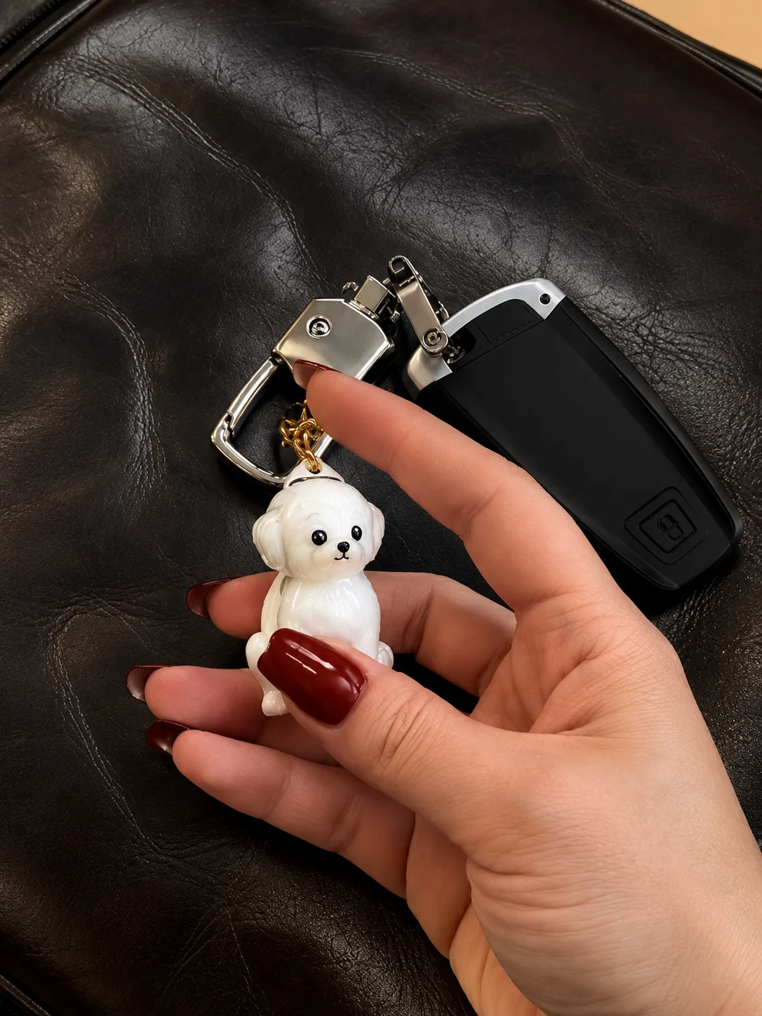 White dog keychain held beside a car key